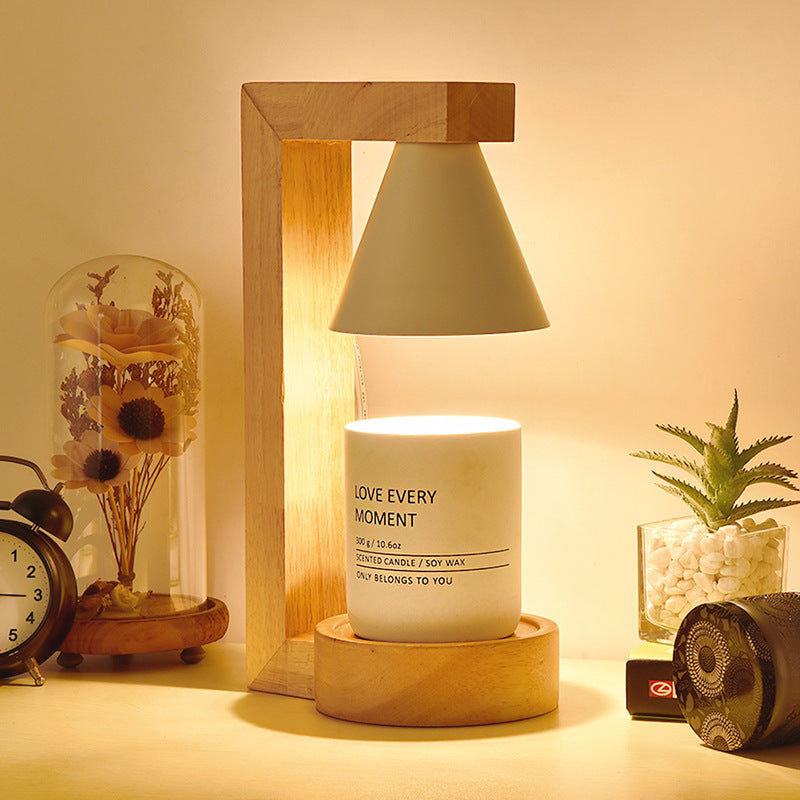 A Japanese style melting wax lamp with a white hood on a bamboo wood base, surrounded by various decor items on a table.