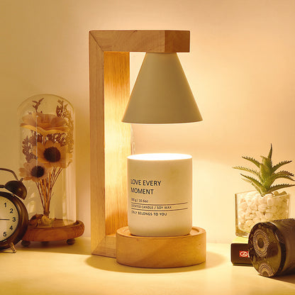 A Japanese style melting wax lamp with a white hood on a bamboo wood base, surrounded by various decor items on a table.