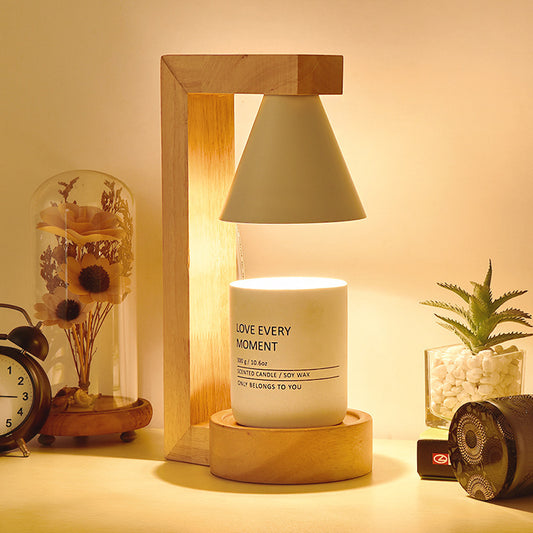 A Japanese style melting wax lamp with a white hood on a bamboo wood base, surrounded by various decor items on a table.