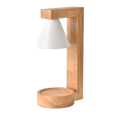 A Japanese style melting wax lamp with a white hood on a bamboo wood base, surrounded by various decor items on a table.